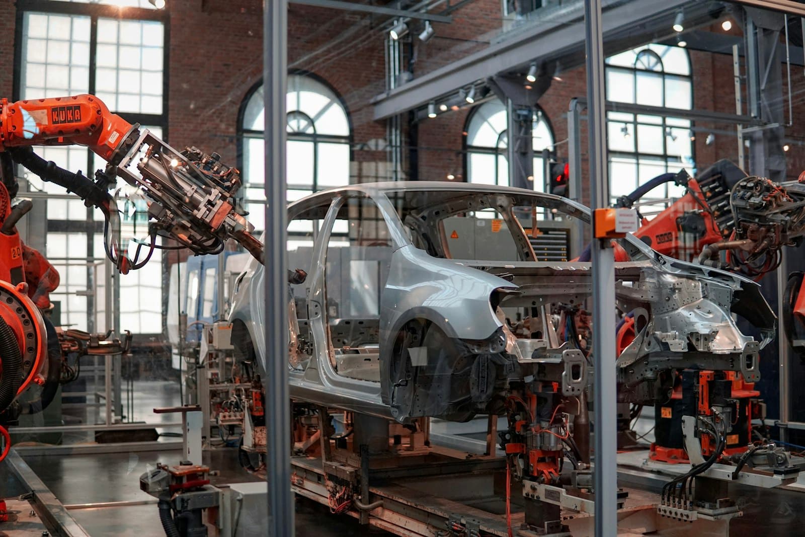 Línea de producción industrial con brazos robóticos ensamblando producto