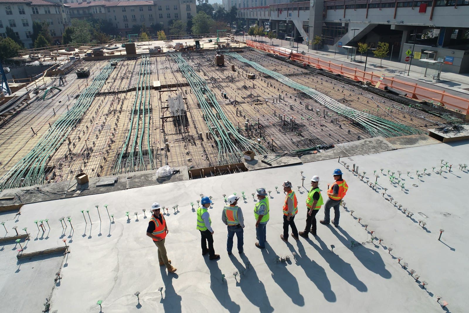 Equipo de trabajadores industriales con equipo de protección reunidos en una nave